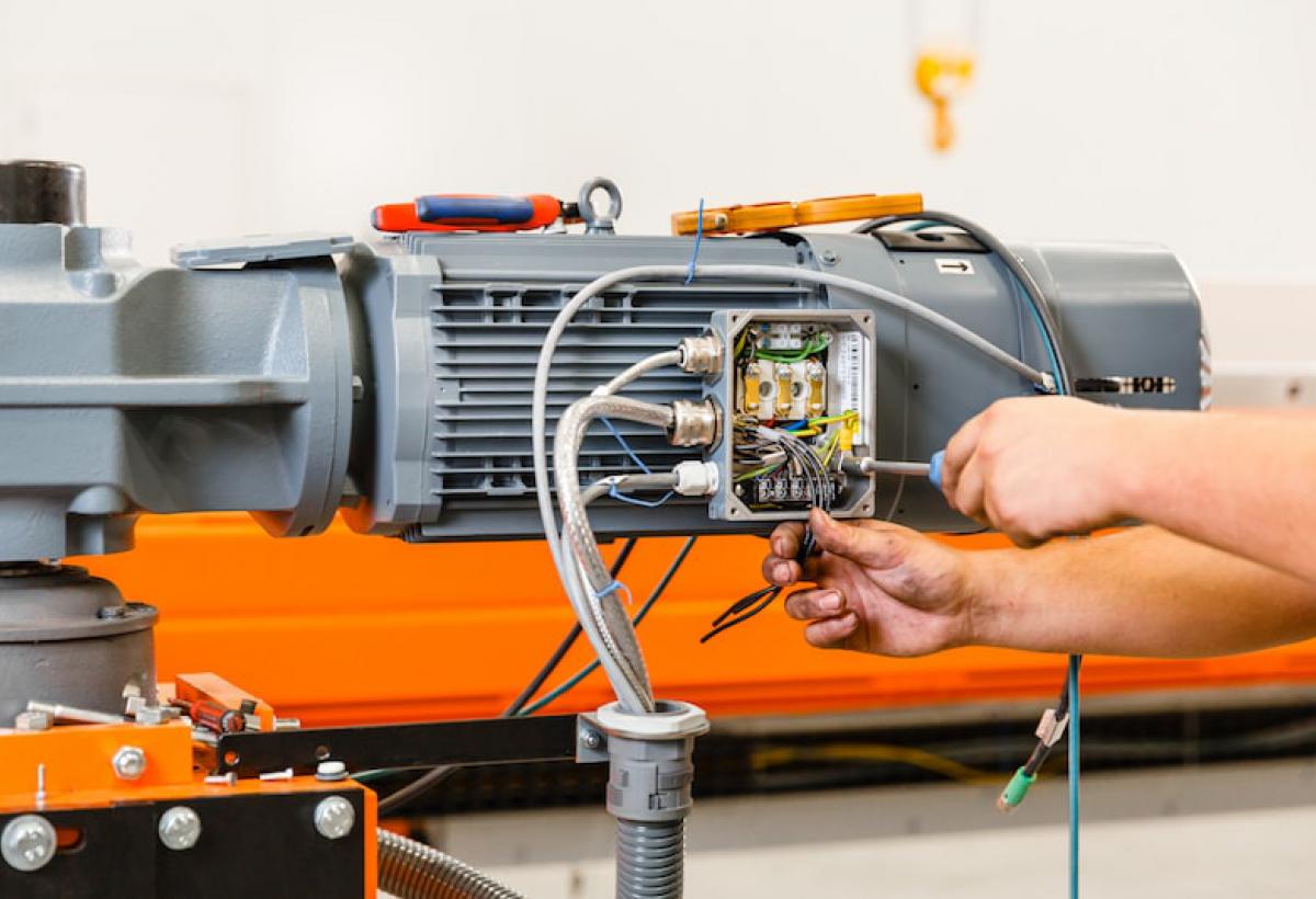 Een servicemonteur van Lalesse assembleert een magazijnkraan. 